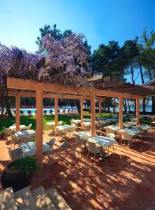 a group of tables and chairs under a pavilion at Hotel Aurora Plava Laguna in Umag