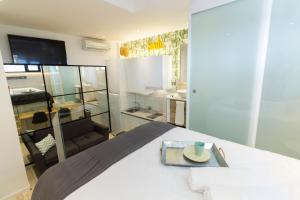 マドリードにあるMonopoly Madrid by gaiaroomsのベッドルーム1室(白いベッド1台付)、テレビが備わります。