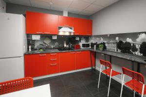 uma cozinha com armários vermelhos e cadeiras vermelhas em Hostel Zolotoye Koltso em Yaroslavl