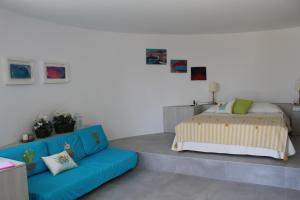 a bedroom with a bed and a blue couch at La Rotonda in Anacapri