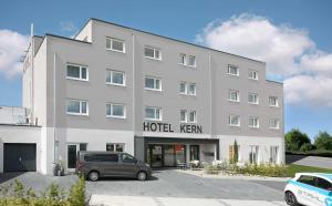 un grande edificio bianco con un hene hotel di Hotel Kern garni a Walddorf