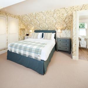 
a bedroom with a bed and a dresser at The Loch Lomond Arms Hotel in Luss
