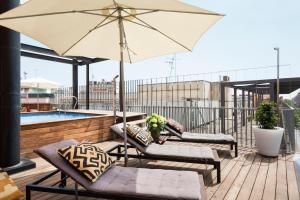 a patio with two chairs and an umbrella on a roof at My Space Barcelona Pool City Center in Barcelona