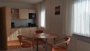 a kitchen with a table and chairs in a room at Apartmenthaus Zwenkau in Zwenkau +34 photos