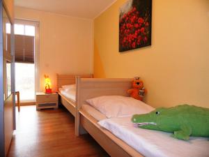 a bedroom with a bed with a stuffed dinosaur on it at Schloonseevilla mit Tiefgarage - 200 m zum Strand in Heringsdorf