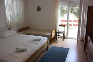 1 Schlafzimmer mit 2 Betten und einer Tür zu einem Balkon in der Unterkunft Apartment Pinta in Pag