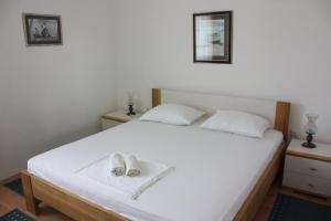 ein weißes Bett mit einem Paar Schuhe drauf in der Unterkunft Apartment Pinta in Pag