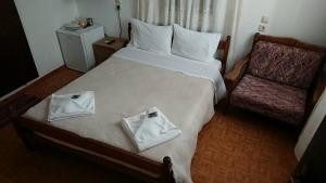 a hotel room with a bed with two towels on it at Maro Rooms in Chania