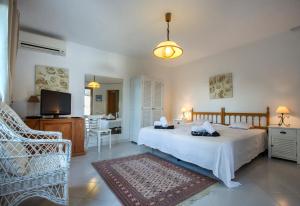 um quarto com uma cama, uma cadeira e uma televisão em Amapola 8 em Xàbia
