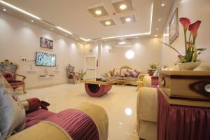 Una gran sala de estar con sofás y un televisor. en قمة النجوم للشقق المخدومة, en Al Ḩanākīyah