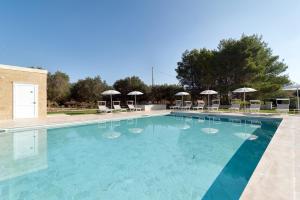 une grande piscine avec des chaises et des parasols dans l'établissement Olive Garden House, à Borgagne