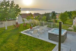a backyard with a hot tub and chairs at Apartments Marin in Senj