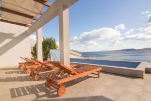 a row of wooden benches sitting on a porch at Apartment Botta in Mimice