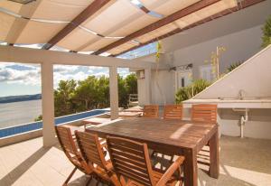 a patio with a wooden table and chairs at Apartment Botta in Mimice