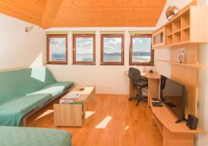 a room with a bed and a desk with a computer at Apartment Botta in Mimice
