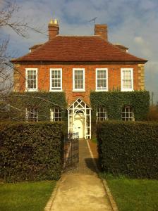 uma grande casa de tijolos vermelhos com uma porta branca em Whitchurch Farm Guesthouse em Alderminster