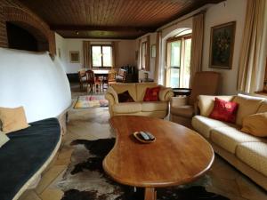 a living room with couches and a wooden table at Villa Leone in Maria Rain