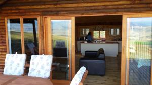 a living room with glass doors and a kitchen at Shepherd Farm in Winterton