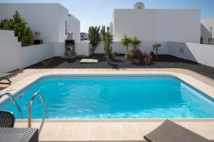 a swimming pool in the backyard of a house at Villas Yaiza in Playa Blanca