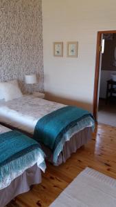a bedroom with two beds with green and white sheets at Shepherd Farm in Winterton