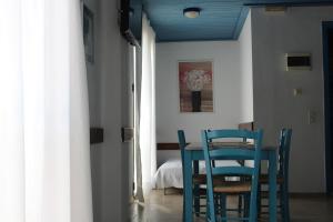 een eetkamer met blauwe stoelen en een tafel bij Glyfada Gorgona Apartments in Glyfada