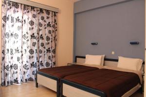 1 dormitorio con cama y cortina en Glyfada Gorgona Apartments, en Glyfada