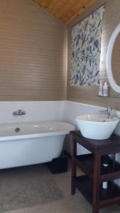 a bathroom with a tub and a sink at Shepherd Farm in Winterton