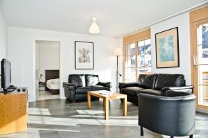ein Wohnzimmer mit einem Sofa und einem Tisch in der Unterkunft Apartment Alpha - GRIWA RENT AG in Grindelwald