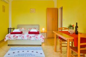 a bedroom with a bed and a table and a dining room at Apartments Marin in Senj