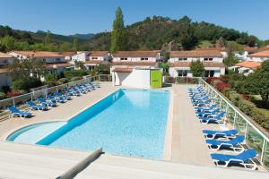 - une piscine avec des chaises longues et un complexe dans l'établissement Zenitude Hôtel-Résidences Mandelieu la Napoule, à Mandelieu-la-Napoule