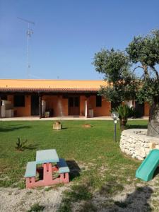 ein Haus mit einem Picknicktisch im Hof in der Unterkunft Il Casale di zio Marco in Torre Chianca