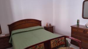 1 dormitorio con cama con marco de madera y vestidor en Le Case di Giorgia, en San Vito lo Capo