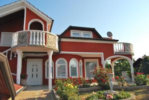 a red house with a balcony and some flowers at apartma Jelka in Novigrad Istria