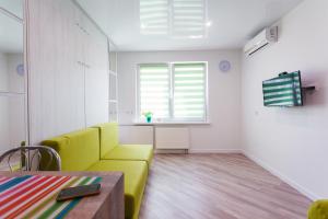 a living room with a yellow couch and a table at Modern Studio Apartments in Kyiv