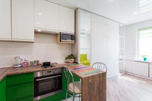 una cucina con armadietti verdi e bianchi e un bancone di Modern Studio Apartments a Kiev