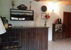 a room with a wooden counter and a clock on the wall at Meson La Huerta in Mascota