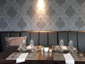 Hotel & Restaurant Schützen في راشتات: غرفة طعام مع طاولة مع كؤوس للنبيذ
