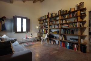 a living room with book shelves filled with books at quindici alberi in Serra deʼ Conti