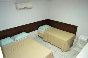 テレジーナにあるHotel Idealのベッド2台とベンチが備わる客室です。