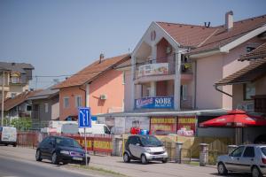 um grupo de carros estacionados numa rua com edifícios em Hostel Larisa em Banja Luka