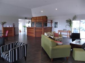 un soggiorno con un divano, sedie e un tavolo di Swan Lake Guest House a Ventnor