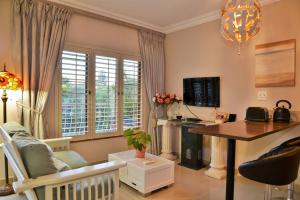 a living room with a desk and a computer in it at Bellgrove Guest House Sandton in Johannesburg