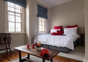 una camera da letto con un letto con cuscini rossi e un tavolo di Seven Gables a Port Elizabeth