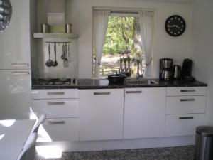 a kitchen with white cabinets and a window at Vosseven in Stramproy
