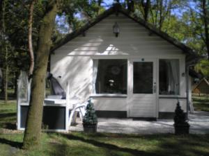 a white shed with a table and a chair in it at Vosseven in Stramproy