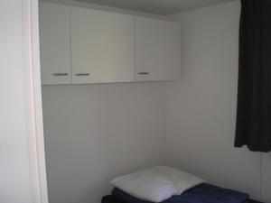 a bedroom with white cabinets and a bed at Vosseven in Stramproy