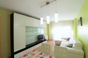 - un salon avec un canapé blanc et une télévision dans l'établissement InmoBooking Marina-Playa, à Cambrils