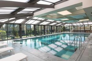 a large swimming pool with glass windows and a large pool at Grand Hôtel Des Thermes in Saint Malo