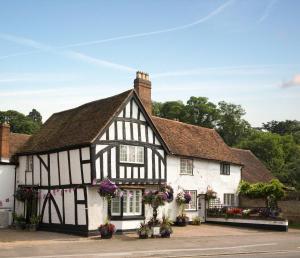 een oud zwart-wit gebouw met bloemen bij Park Cottage in Warwick