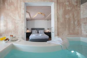 ein Bad mit Badewanne und ein Bett in einem Zimmer in der Unterkunft Villa Galinia in Akrotiri